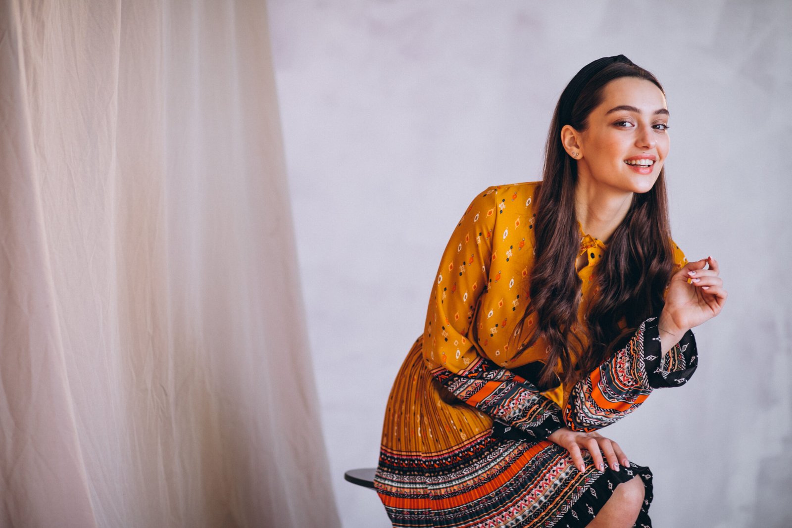 Young woman in a beautiful yellow dress in studio
